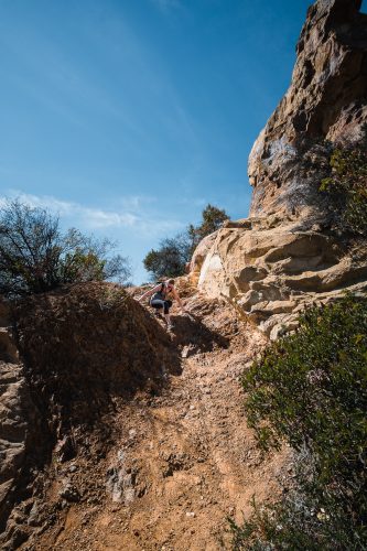 Scrambling on the rocks at the top of Temescal Canyon Trail in Topanga State Park in Los Angeles, California.